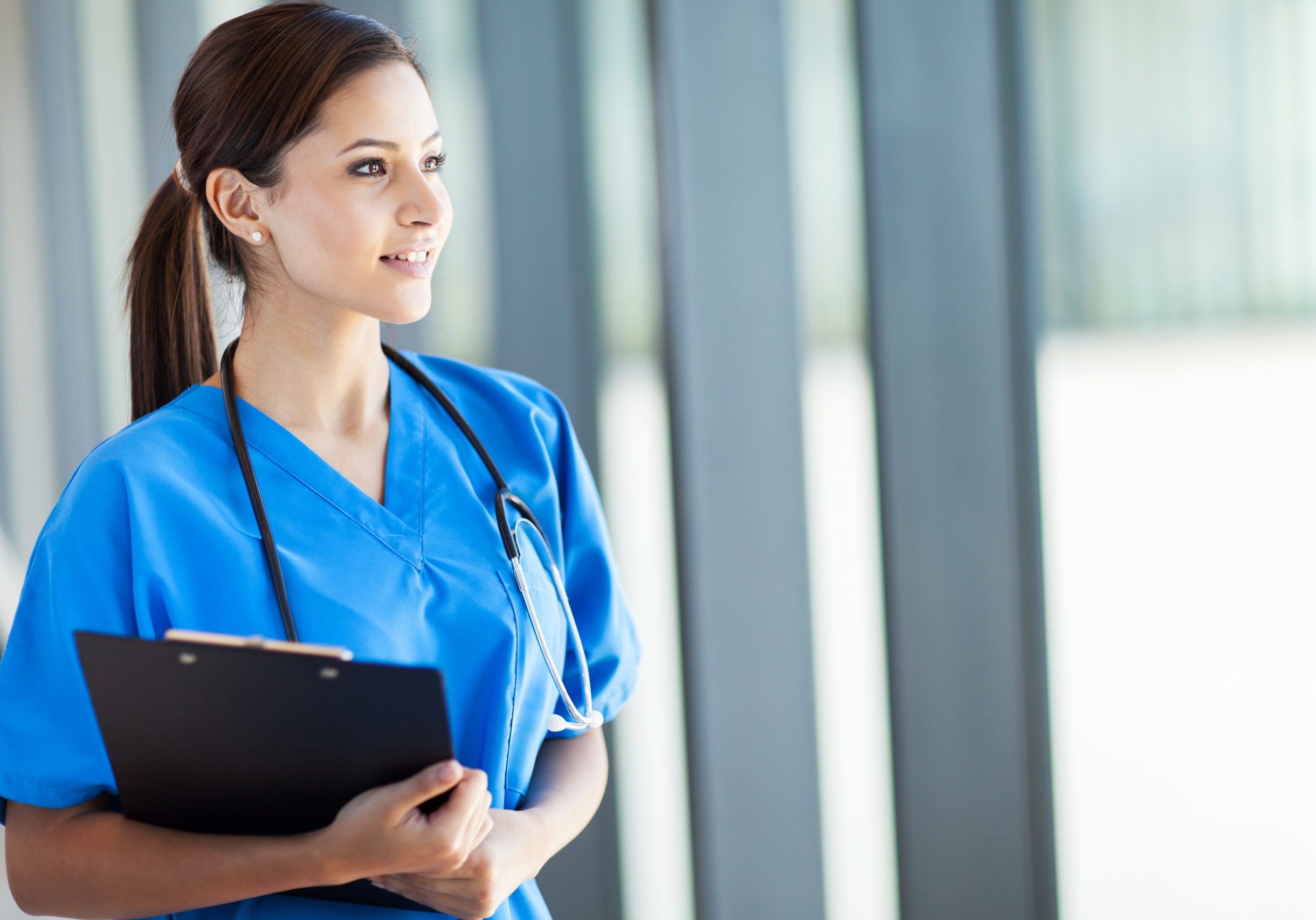 beautiful young female medical intern looking outside window